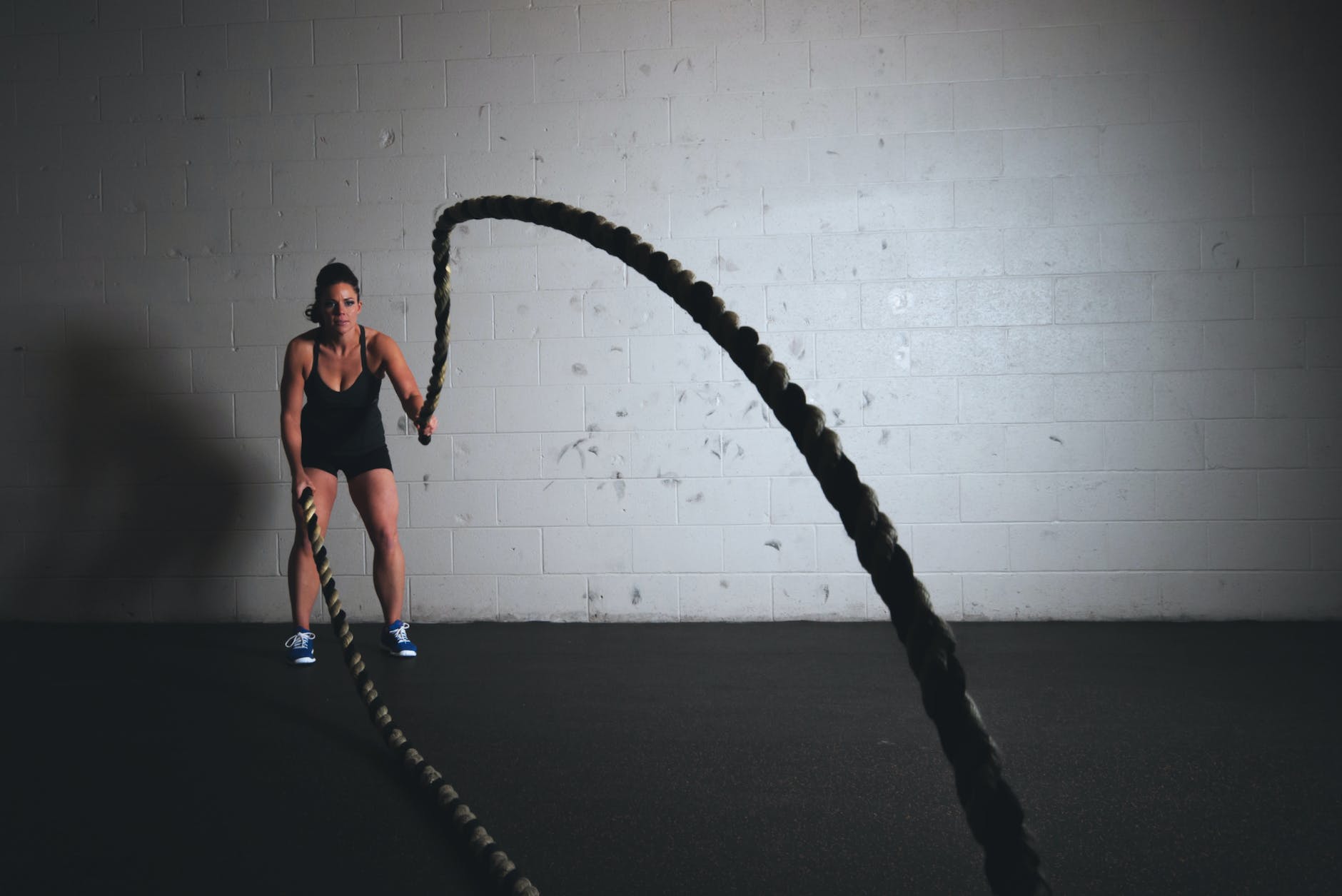 woman holding exercise ropes doing high-intensity interval training